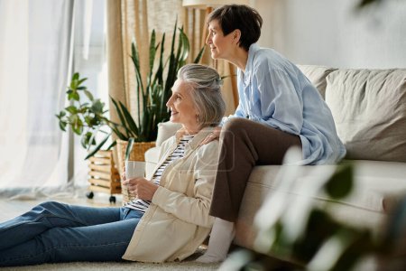 Two elderly women sit peacefully on a cozy living room couch.