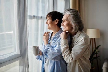 Two elderly women peacefully observe the view outside.