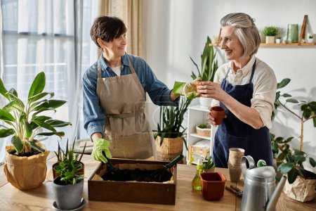 Zwei Frauen in Schürzen pflanzen gemeinsam ein neues grünes Leben.