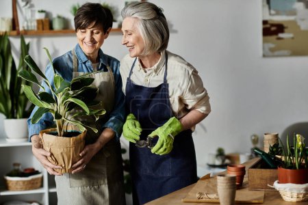Mature lesbian couple in aprons tend to a potted plant.