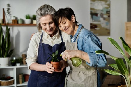Two women in aprons standing by a potted plant.
