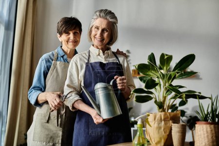 Two women in aprons tending to a potted plant together.
