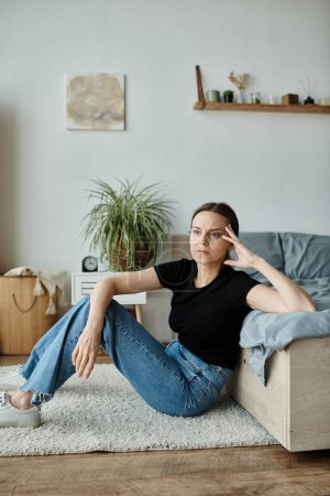 Téléchargez les photos : A middle-aged woman embracing solitude and contemplation while seated on the bedroom floor. - en image libre de droit