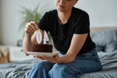 Woman holding a cake with the number 40 on it.