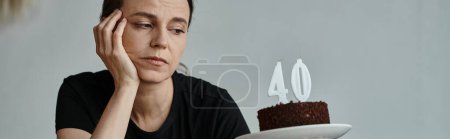 Téléchargez les photos : A woman joyfully holding a cake with a 40 candle on it. - en image libre de droit
