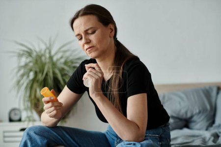 Woman in distress on bed with pills in hand.