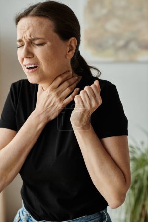 Depressed middle-aged woman at home experiencing neck pain.