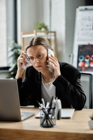 Téléchargez les photos : A woman, visibly stressed, talks on the phone while seated at a desk. - en image libre de droit