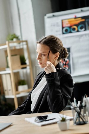 Middle-aged woman in business suit, experiencing stress at office desk.