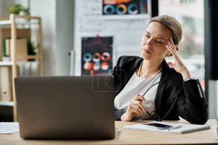 Stressed woman in crisis working with laptop at desk.