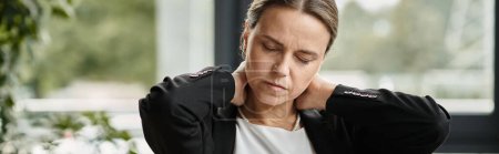 Woman holding neck in pain at office, depression.