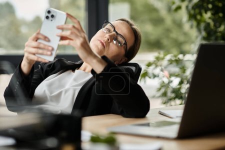 Photo for Woman in glasses looking at phone in stress. - Royalty Free Image