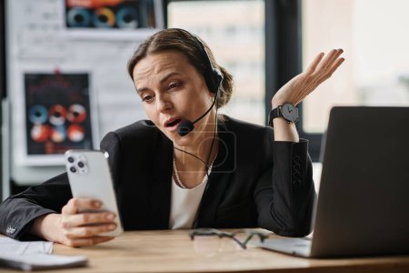 A middle-aged woman in a headset looks at her phone, overwhelmed with stress and signs of mental breakdown.