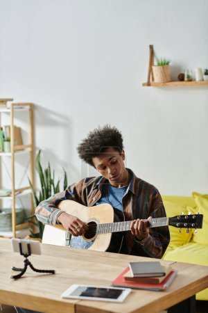 A young African American man playing an acoustic guitar in his cozy living room.