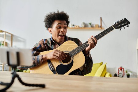 Young man plays acoustic guitar in living room.