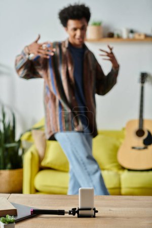 A young African American man strums a guitar in a warm living room.