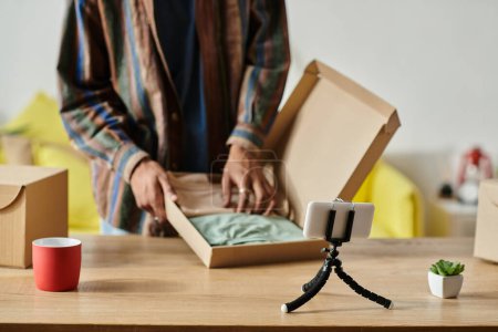 Téléchargez les photos : A man revealing the contents of a box while sitting at a table. - en image libre de droit