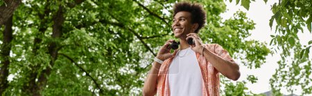 Téléchargez les photos : Young man using headphones in park. - en image libre de droit