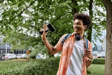Téléchargez les photos : Jeune homme prenant selfie dans le parc
. - en image libre de droit