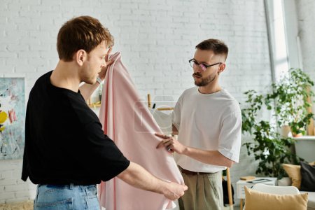 Two fashion designers, a gay couple, stand together in their designer workshop, immersed in creating trendy attire.