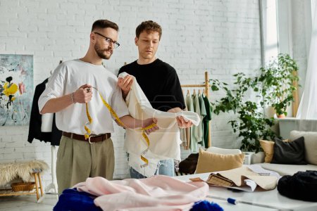 Two gay men collaborate on fashionable designs in a chic workshop.