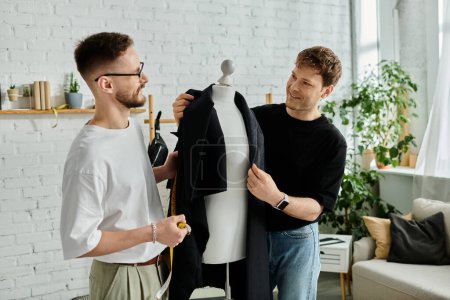 Two men, a gay couple, stand beside each other, attentively observing a dress displayed on a mannequin.