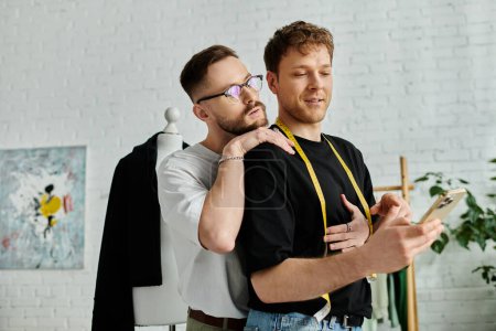 Photo for Two men, fashion designers, stand side by side in their workshop. - Royalty Free Image