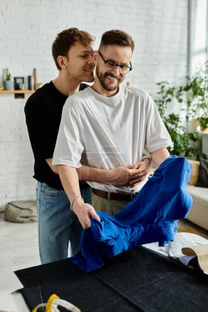 Two men, a gay couple, stand together in a designer workshop, passionately creating trendy attire.