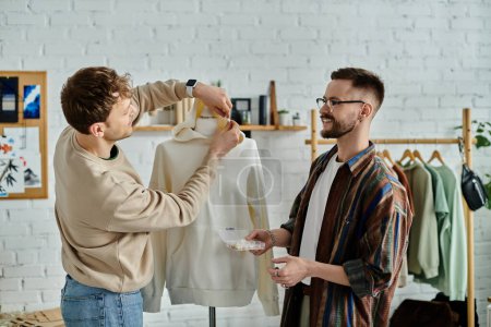 Deux hommes se tiennent à côté d'un mannequin dans un atelier de designer