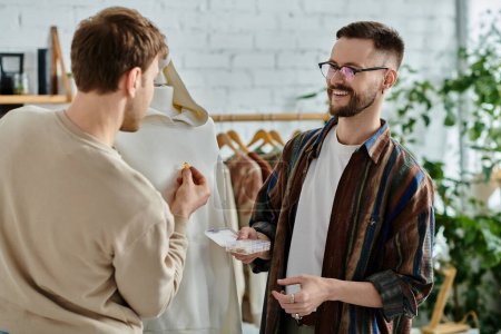 Dos hombres discuten ideas de diseño en una tienda de ropa elegante.