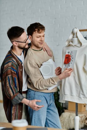 Zwei Männer, Teil eines schwulen Paares, studieren sorgfältig ein modisches Hemd, das auf einer Schaufensterpuppe abgebildet ist.