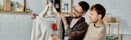 Deux hommes, un couple gay, se tiennent ensemble dans un atelier de designer, collaborant à la création de vêtements tendance.