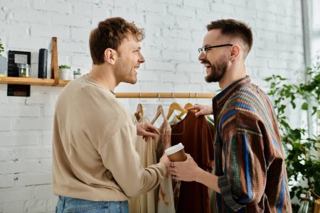 Dos diseñadores de moda masculinos colaboran en la ropa con estilo en un taller.