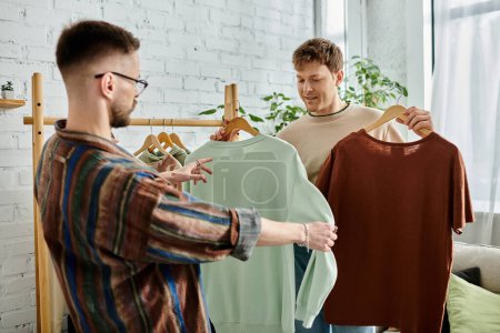gay couple admiring shirt on rack in designer workshop.