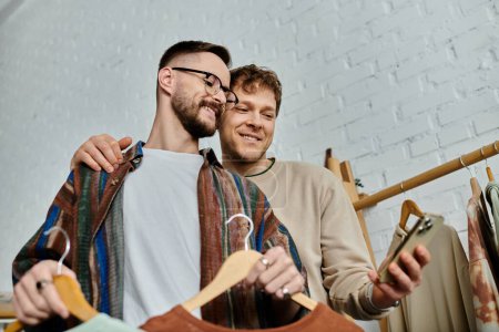 Téléchargez les photos : Deux hommes, partenaires en amour et en design, se tiennent côte à côte dans un atelier de designers. - en image libre de droit