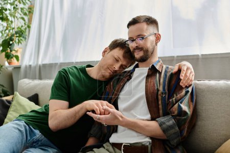 Two men in love in fashionable attire while sitting on top of a couch.