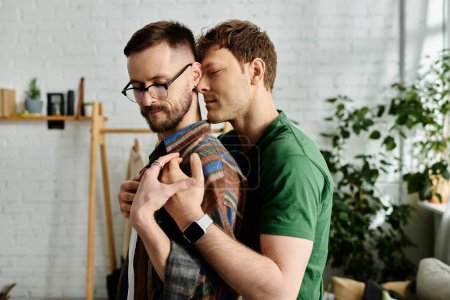 Foto de Two men, a gay couple, stand side by side in a designer workshop, creating trendy attire for a fashion show. - Imagen libre de derechos