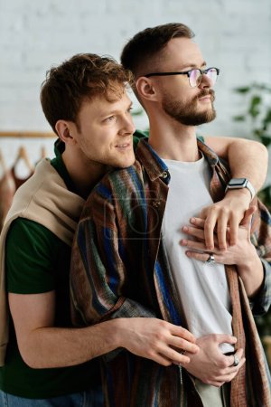 Téléchargez les photos : Two men stand together in a designer workshop, passionately crafting trendy attire. - en image libre de droit