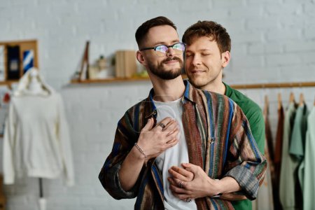 Two men hugging while standing together in atelier