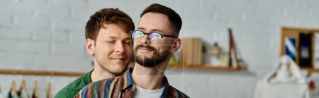 Téléchargez les photos : Deux hommes, un couple gay, se tiennent côte à côte dans un atelier de designer, confectionnant passionnément des vêtements tendance. - en image libre de droit