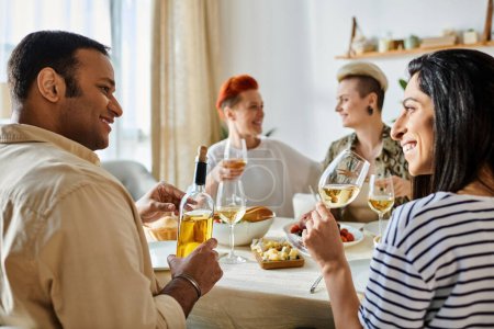 Vielfältige Freundesgruppe genießt Abendessen und Gespräche am Tisch mit Weingläsern.