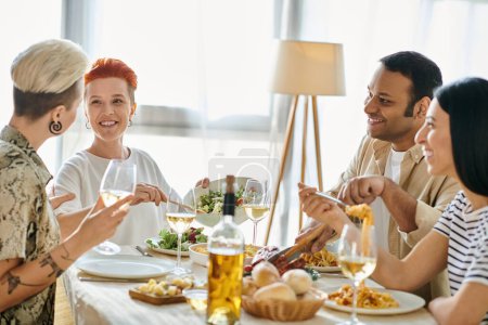 Un grupo diverso de amigos disfrutan de una comida juntos en una mesa de cena organizada por una pareja lesbiana amorosa.