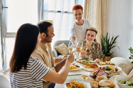 Diverse friends accompany a loving lesbian couple as they enjoy dinner together at home.
