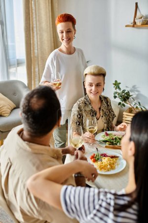 Photo for Diverse group enjoys home-cooked meal with laughter and conversation. - Royalty Free Image