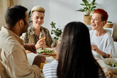 Diverse friends and a loving lesbian couple share a meal together around a table at home.
