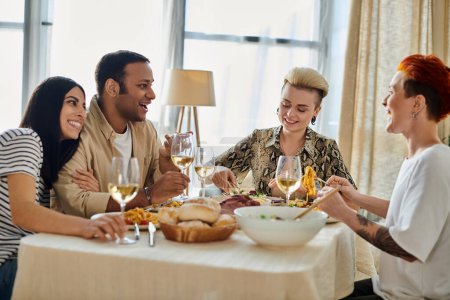 A group of people enjoying food and wine together at a table.