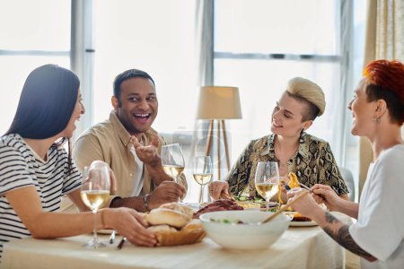 Foto de Diverso grupo disfrutando de la cena con vino en la mesa. - Imagen libre de derechos