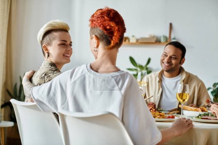 Téléchargez les photos : Diverse group enjoying dinner at home, including a loving lesbian couple. - en image libre de droit