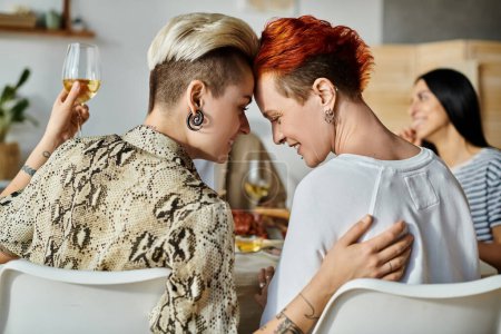 Foto de Una pareja lesbiana disfrutando de la cena con amigos en casa. - Imagen libre de derechos