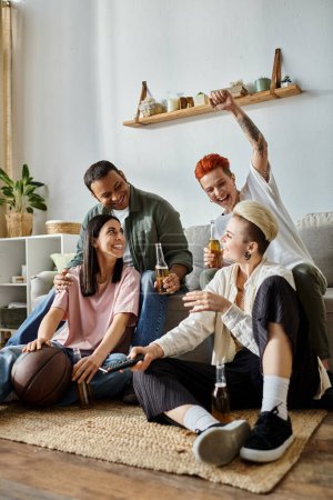Photo for Diverse group of friends, including a loving lesbian couple, sit on the floor, enjoying beer together. - Royalty Free Image